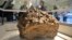 Reporters gather around a piece of a meteorite, which according to local authorities and scientists, was lifted from the bottom of the Chebarkul Lake, placed on display in a local museum in Chelyabinsk, Russia, Oct. 18, 2013.