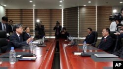 Hwang Boogi, left, South Korea's vice minister of unification and the head negotiator for high-level talks with North Korea, talks as his North Korean counterpart Jon Jong Su, right, listens during their meeting, Dec. 11, 2015.