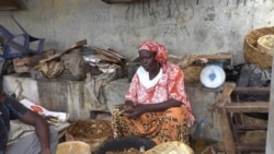 Aminta Seck dries and cures fish in a cramped space since rising sea levels have pushed her work inland (Photo: E. Sarai/VOA)