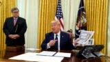 President Donald Trump speaks before signing an executive order aimed at curbing protections for social media giants, in the Oval Office, May 28, 2020, in Washington, as Attorney General William Barr listens. 