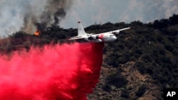 A firefighting aircraft makes a low-altitude pass to drop fire retardant to battle a wildfire near Bradbury, Calif., June 22, 2016