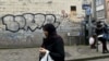 A woman passes close to the house where Salah Abdeslam, the most-wanted fugitive from November's Paris attacks, was arrested on March 18 after a shootout with polic in the Brussels district of Molenbeek, March 19, 2016.