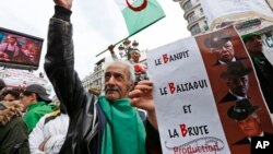 Un manifestant arbore une pancarte faisant référence aux trois B, Abdelkader Bensalah, Tayeb Belaiz et Noureddine Bedoui, des membres de l’équipe dirigeante de la transition, dont les algériens ne veulent plus, lors d'un rassemblement à Alger, le vendredi 5 avril 2019.