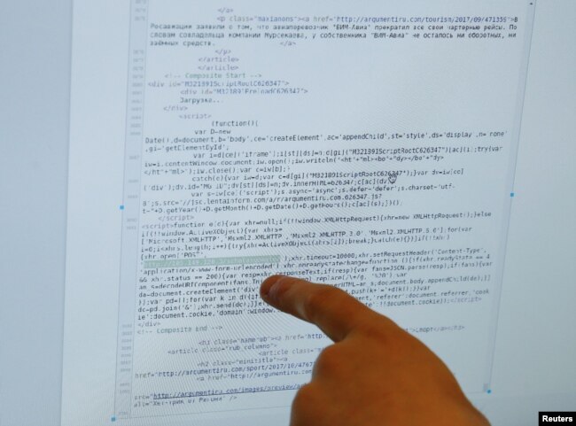 Seorang karyawan menunjukkan, apa yang dia katakan adalah bagian dari skrip jahat yang digunakan selama serangan virus Bad Rabbit, di layar komputer di markas besar Polisi Cyber Ukraina di Kiev, Ukraina. (Foto: Reuters)REUTERS/Valentyn…