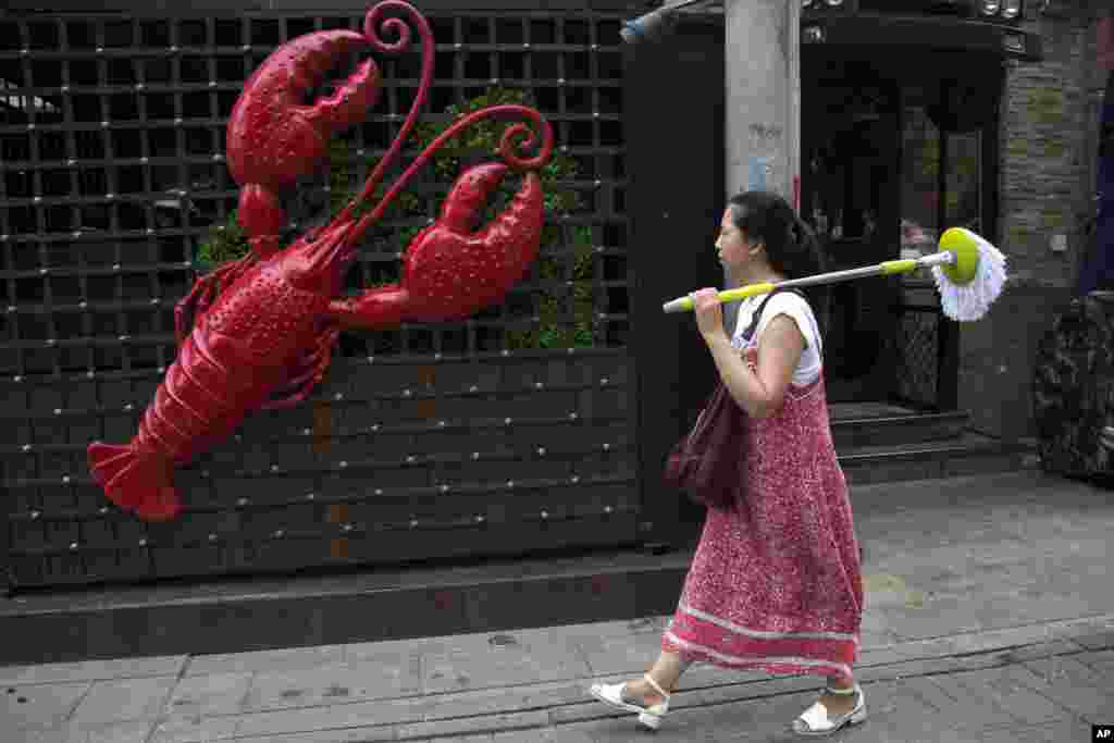 گذر یک شهروند چینی از مقابل رستوران خرچنگ در چین