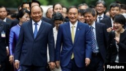 Japanese Prime Minister Yoshihide Suga (R) and his Vietnamese counterpart Nguyen Xuan Phuc walk together after the welcoming ceremony at the Presidential Palace in Hanoi, Vietnam October 19, 2020. (REUTERS/Kham/Pool)