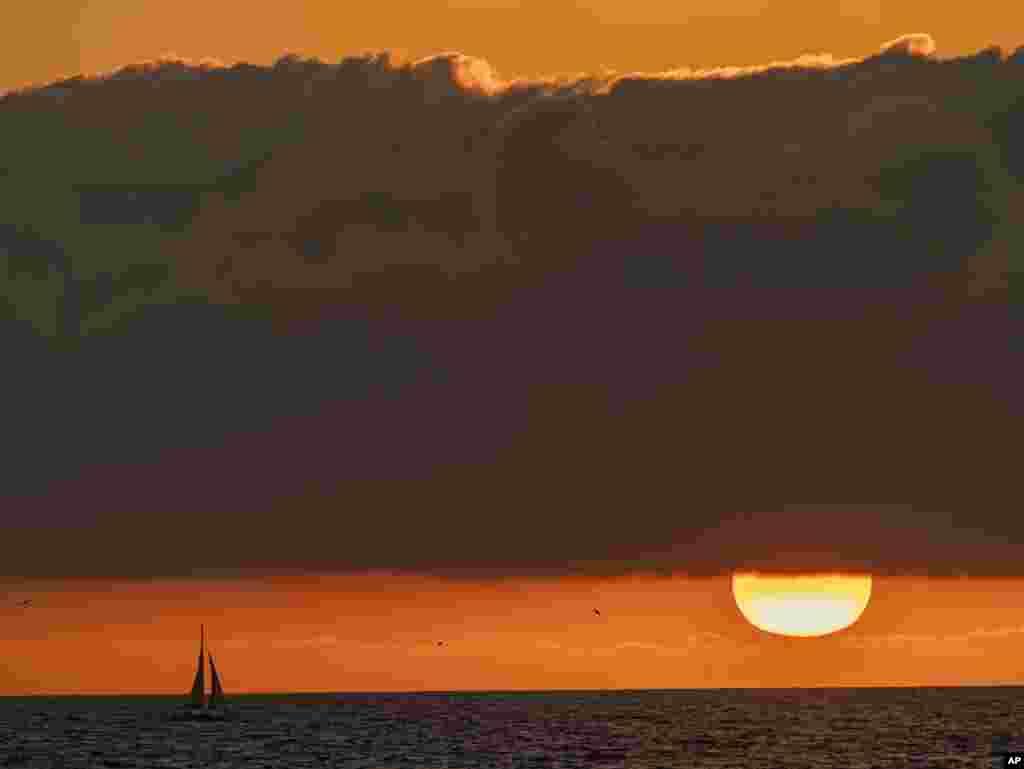 A boat sails on the Pacific Ocean off the coast of Venice Beach during sunset in Los Angeles, California, December 27, 2020.&nbsp;Southern California&#39;s first major storm of the season is expected to bring rain and snow to the area, according to the National Weather Service.