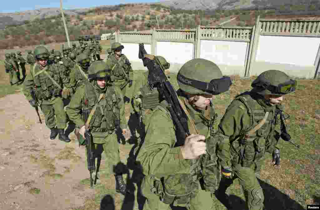 Military personnel, believed to be Russian servicemen, walk in formation outside the territory of a Ukrainian military unit in the village of Perevalnoye outside Simferopol, March 3, 2014.