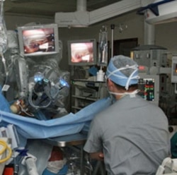 A surgeon performs an operation using robotic assistance