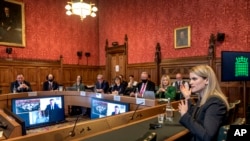 In this handout photo provided by UK Parliament, Facebook whistleblower Frances Haugen, right, gives evidence to the joint committee for the Draft Online Safety Bill, as part of government plans for social media regulation, in London, Oct. 25, 2021.