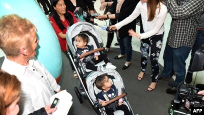 Batita kembar siam berusia 15 bulan asal Bhutan, Nima dan Dawa didampingi ibu mereka, Bhumchu Zangmo, saat meninggalkan Rumah Sakit Anak Royal Melbourne, Senin, 26 November 2018. (Foto: AFP).