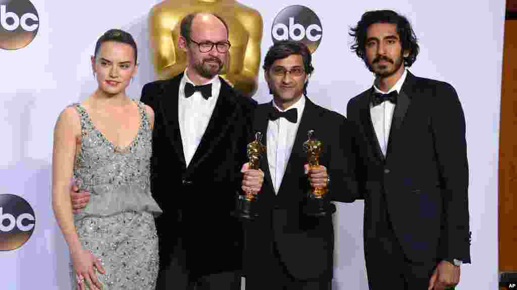 Daisy Ridley, Dev Patel, James Gay-Rees et Asif Kapadia, posent avec le prix du meilleur documentaire pour les photographes dans la salle de presse, 28 février 2016.