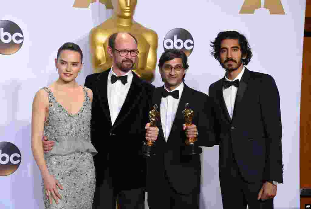 Daisy Ridley, kiri, dan Dev Patel, kanan, berpose di ruang pers bersama James Gay-Rees, kiri, dan Asif Kapadia, pemenang dokumenter panjang &ldquo;Amy&rdquo;, di Oscars, 28 Februari 2016, di Dolby Theatre, Los Angeles.