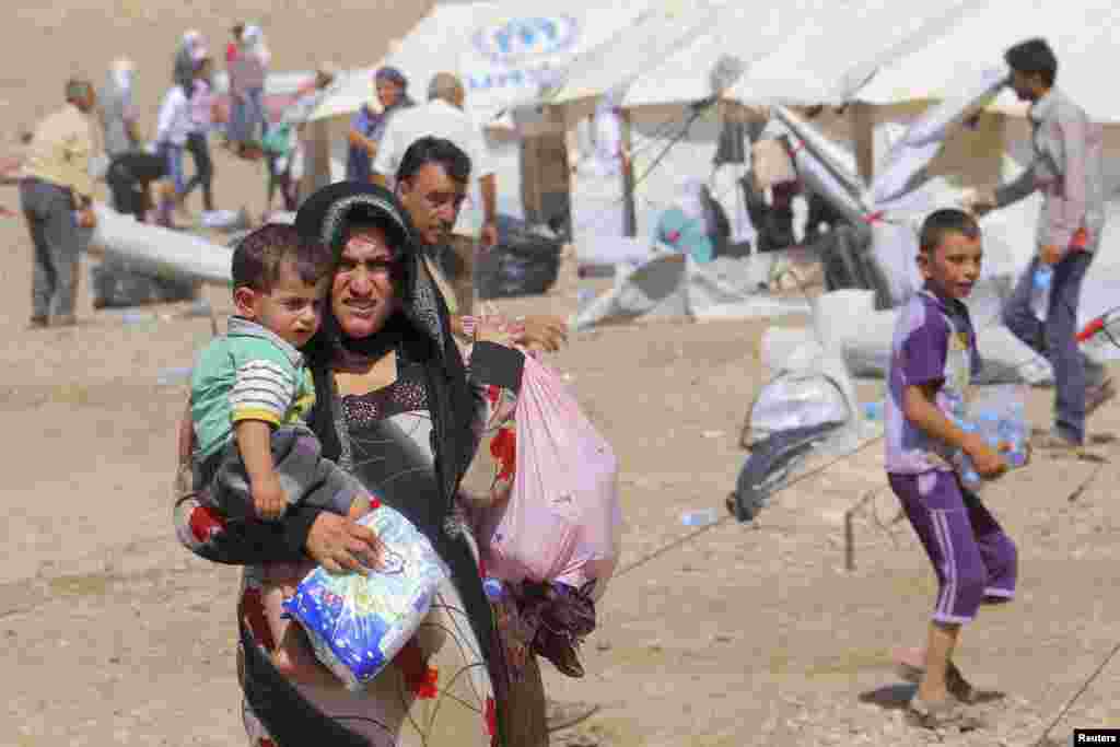 Syrian refugees who fled the violence in Syria, are seen at a refugee camp in Arbil, about 350 km (220 miles) north of Baghdad August 16, 2013. Thousands of Syrian refugees poured into the Kurdistan region of northern Iraq on Thursday, taking advantage of