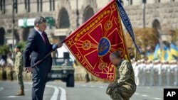 Tổng thống Ukraine Petro Poroshenko trao quốc kỳ cho một đơn vị quân sự trước cuộc diễu hành kỷ niệm ngày Quốc khánh của Ukraina ở thủ đô Kiev hồi tháng Tám.