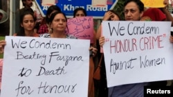 Members of civil society and the Human Rights Commission of Pakistan hold placards during a protest in Islamabad, May 29, 2014.