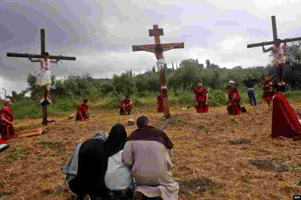 Lebanese Christian men are tied to wooden crosses as they and fellow worshippers re-enact the crucifixion of Jesus Christ, during Good Friday celebrations in the southern village of al-Qurayeh, near the port city of Sidon.