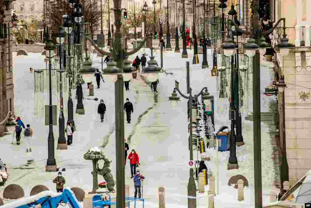 People walk through snow in downtown Madrid, Spain.