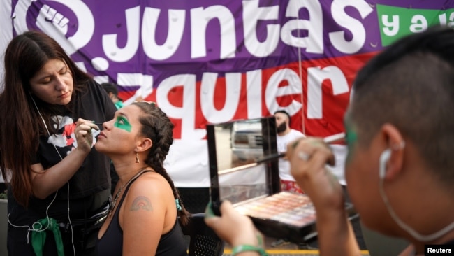 Mujeres se preparan antes de una protesta que marca el Día Internacional de la Mujer en la Plaza de Mayo en Buenos Aires, Argentina, el 8 de marzo de 2020.