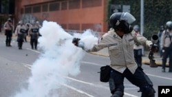 Un Policía de la Guardia Nacional Bolivariana lanzó una bomba de gas lacrimógeno contra manifestantes durante una manifestación en Caracas, Venezuela, el sábado 8 de abril de 2017.