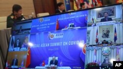A TV screen shows Vietnamese Prime Minister Nguyen Xuan Phuc, center, addressing the Special ASEAN summit online to discuss actions coping with the COVID-19 pandemic, Hanoi, Vietnam Tuesday, April 14, 2020. (AP Photo/Hau Dinh)