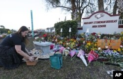 Warga meletakkan bunga di luar SMA Marjory Stoneman Douglas di Parkland, Florida pada peringatan setahun insiden penembakan di sana, 14 Februari 2019 lalu.