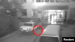 A man attacks a vehicle parked outside an office building of a special patrol squadron at Lukqun Township in northwest China's Xinjiang Uygur Autonomous Region in this image released by CCTV, June 26, 2013.