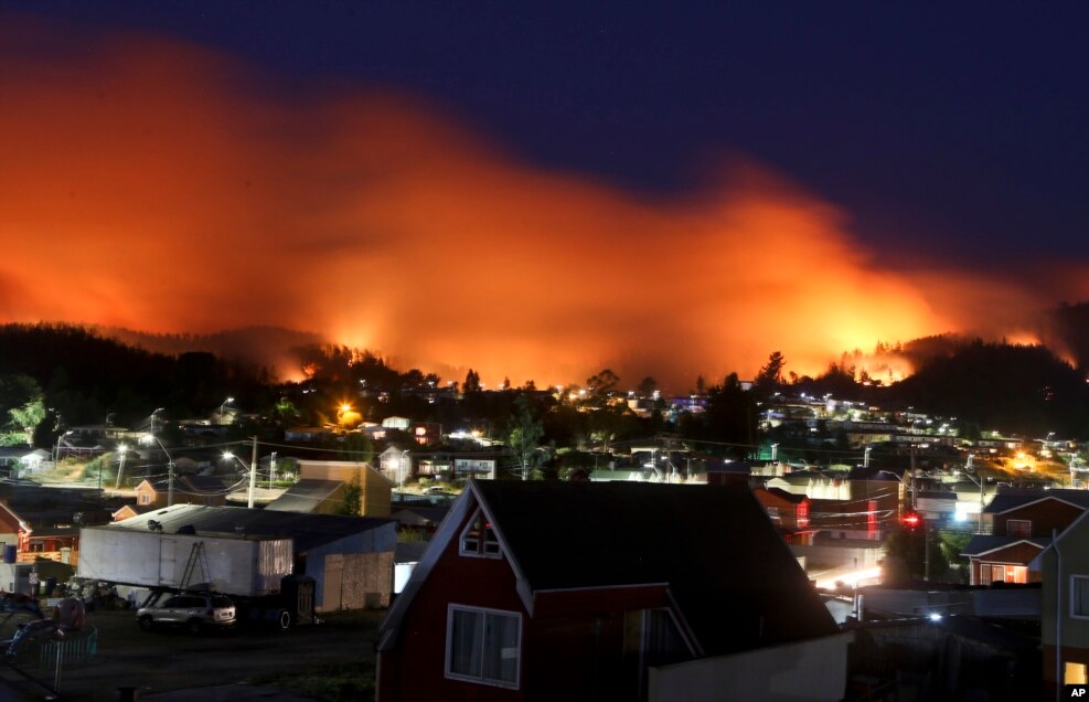 A wildfire approaches Chile's Dichato community, Jan. 30, 2017, where firefighters are working to keep the flames away from the estimated 800 homes.