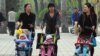 Women push babies in prams through a Beijing park during a public holiday, April 5, 2011.