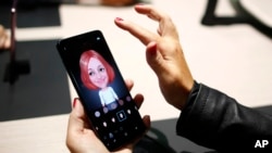 A woman holds the new Galaxy S9 during the Samsung Galaxy Unpacked 2018 event on the eve of the Mobile World Congress wireless show, in Barcelona, Spain, Feb. 25, 2018. 