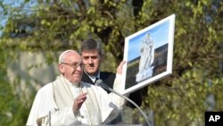 El Papa Francisco sostiene una imagen enmarcada de la Virgen durante su visita al barrio Forlanini de Milán conocido como Case Bianche como parte de su visita pastoral de un día a Monza y Milán, la segunda ciudad más grande de Italia, el sábado 25 de marzo , 2017.