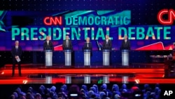 Democratic presidential candidates from left, former Virginia Sen. Jim Webb, Sen. Bernie Sanders, of Vermont, Hillary Rodham Clinton, former Maryland Gov. Martin O'Malley, and former Rhode Island Gov. Lincoln Chafee take the stage before the CNN Democratic presidential debate Tuesday, Oct. 13, 2015, in Las Vegas. On the far left is moderator Anderson Cooper. (AP Photo/John Locher)