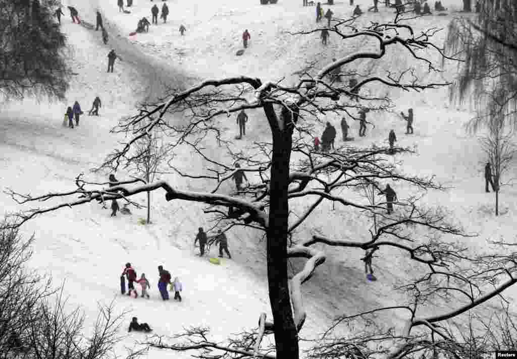 People enjoy the snow at Greenwich Park in London.