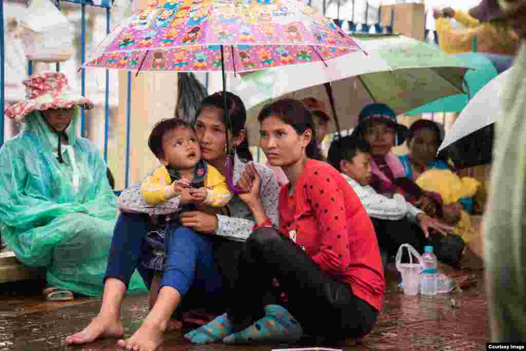 ស្ត្រី​វ័យ​ក្មេង​ដែល​មក​ពី​សហគមន៍​ក្នុង​ខេត្ត​កោះកុង​អង្គុយ​ក្រោម​មេឃ​ភ្លៀង នៅ​មុខ​តុលាការ​ខេត្ត​កោះកុង ដើម្បី​ទាមទារឲ្យ​ដោះលែង​សកម្មជន​បរិស្ថាន​ទាំង​បីនាក់​របស់​ចលនា​មាតាធម្មជាតិ កាលពី​ថ្ងៃច័ន្ទ ទី២៧ ខែមិថុនា ឆ្នាំ២០១៦។ (រូបថត​ដោយ​អ្នកនាង ម៉ម កល្យាណី)