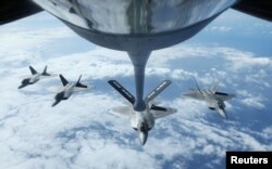 FILE - Four F22 Raptors fly in formation after a mid-air refueling exercise with a KC-135R Stratotanker as they participate in the multi-national military exercise RIMPAC in Honolulu, Hawaii, July 26, 2016.