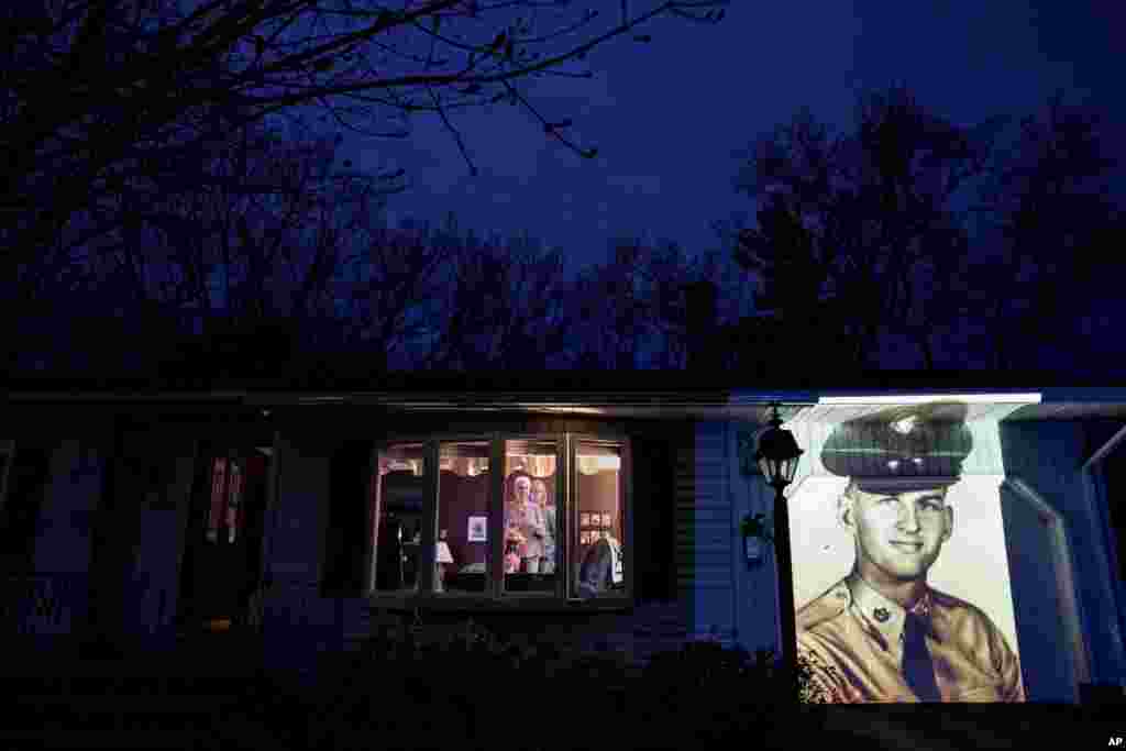 Фотография ветерана армии США Фрэнсиса Фоули проецируется на дом его жены Дейл Фоули (слева) в Чикопи, штат Массачусетс. Фоули скончался от COVID-19 в возрасте 84 лет (фото: AP/David Goldman)