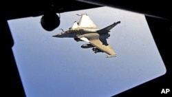 A French Rafale fighter jet approaches an airborne Boeing C-135 refueling tanker aircraft from the Istres military air base during a refueling operation above the Mediterranean Sea, Mar 25 2011