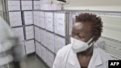 Le personnel médical du dépôt national de vaccins de Nairobi, où le premier lot de vaccins COVID-19 du pays est conservé dans une chambre froide, contrôle les vaccins dans une chambre froide à Nairobi le 4 mars 2021.