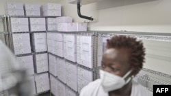 Le personnel médical du dépôt national de vaccins de Nairobi, où le premier lot de vaccins COVID-19 du pays est conservé dans une chambre froide, contrôle les vaccins dans une chambre froide à Nairobi le 4 mars 2021.
