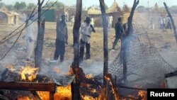 Des Sud-soudanais constatent les dégâts causés par un raid aérien du Soudan près de Bentiu, le 23 avril 2012.