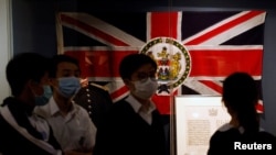 香港中學生走過香港歷史博物館內的一面港英旗幟。（路透社：2020年20月16日）