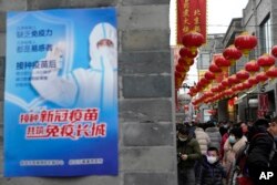 资料照：北京街头一幅接种新冠疫苗的宣传画。（2021年2月14日）