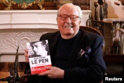 Jean-Marie Le Pen, founder of France's far-right National Front political party, holds his book of memoirs in Montrerout, France, Feb. 27, 2018.