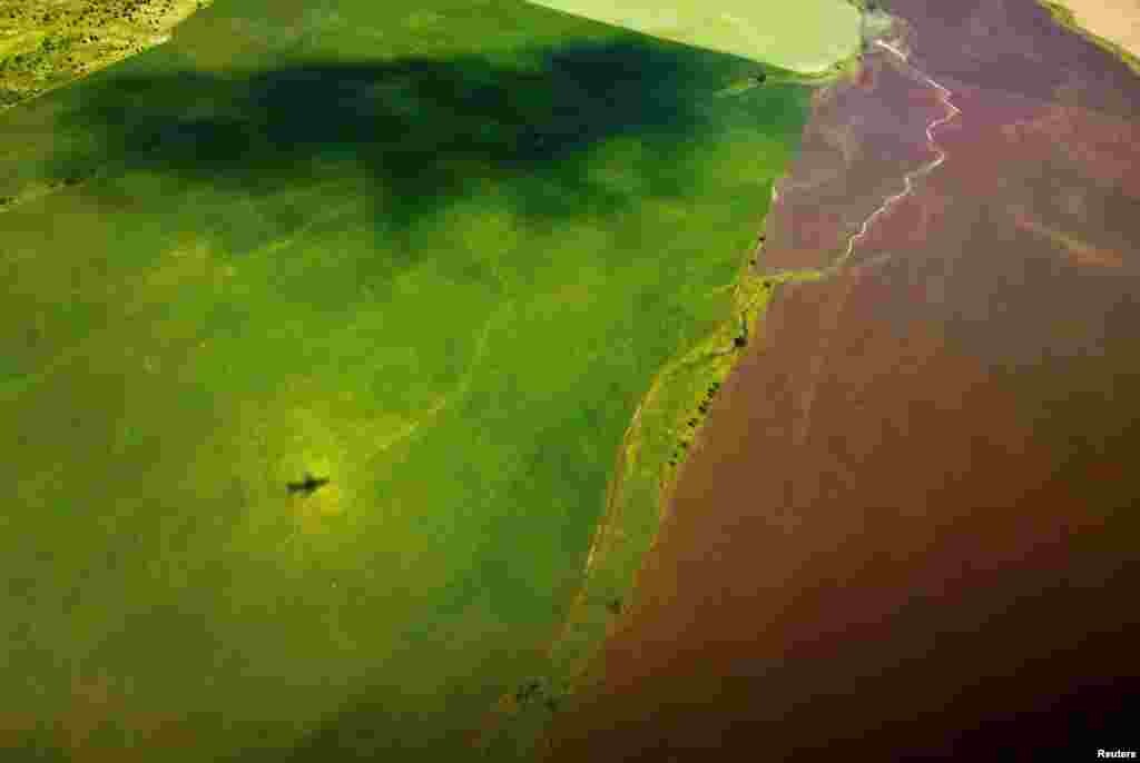 The shadow of a plane is seen in a field shortly after take-off from Samara Airport in Russia, July 8, 2018.