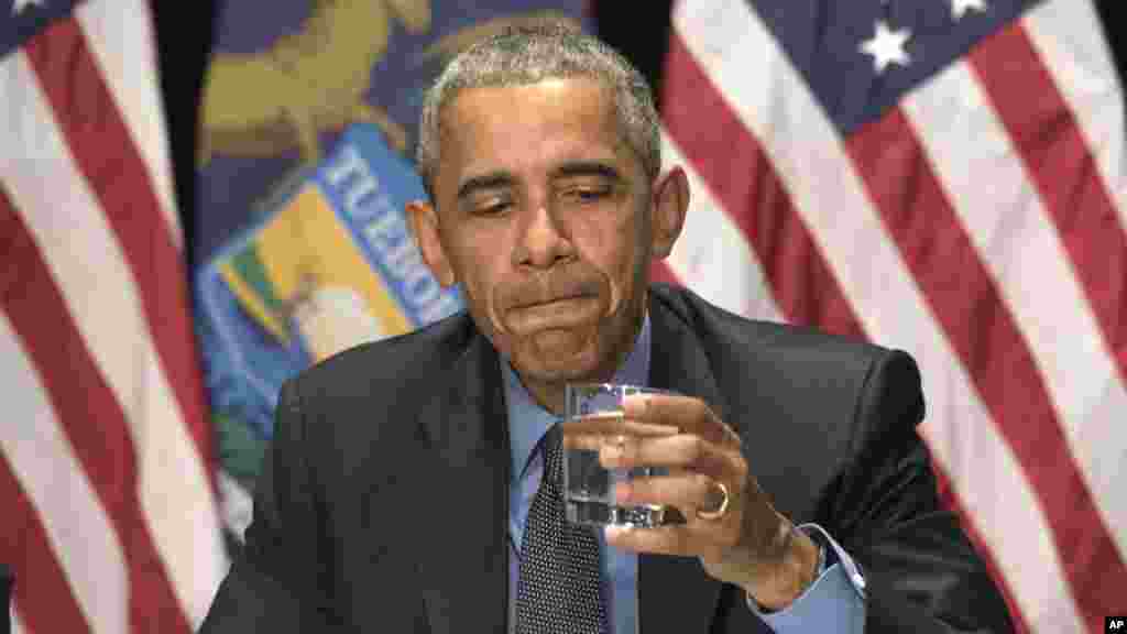 Le président Barack Obama boit un verre d'eau filtrée au cours d'une réunion avec des fonctionnaires fédéraux du Michigan à Flint, le 4 mai 2016.