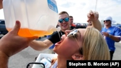 University of Florida student Sam Lowe, 21, drinks out of a jug while celebrating with friends at a college football game.