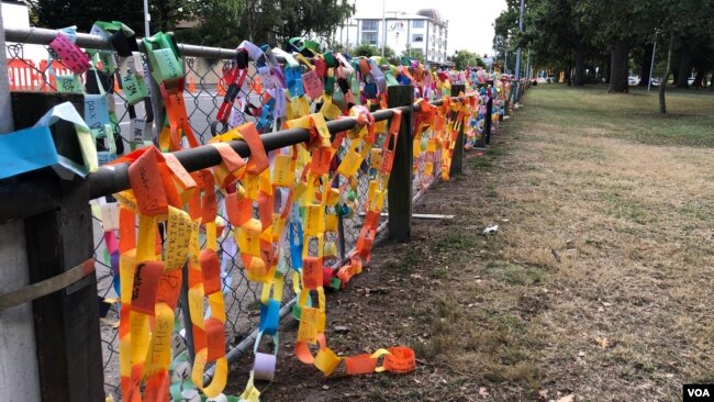 Paper links are draped over the fence at Hagley Park near one of the mosques were more than 40 people were killed in Christchurch March 15. (S. Miller/VOA)
