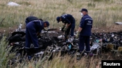 Members of the Ukrainian Emergencies Ministry work at a crash site of Malaysia Airlines Flight MH17, near the village of Hrabove, Donetsk region, July 20, 2014. 