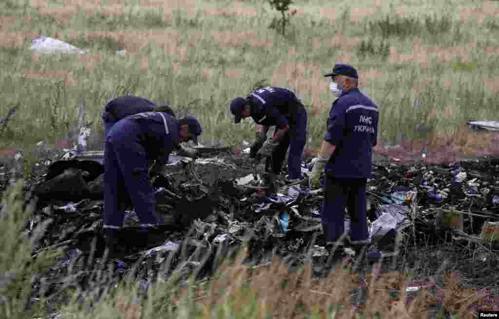 Para pegawai Kementerian Darurat Ukraina bekerja di lokasi jatuhnya pesawat Malaysia Airlines dengan nomor penerbangan MH17, dekat desa Hrabove, di wilayah Donetsk (20/7).