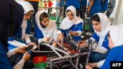 Members of the Afghan all-girls robotics team make adjustments to the team robot Hall, in Washington, DC.